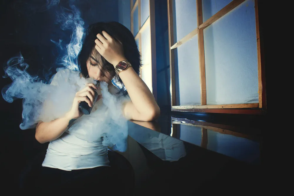抽一次性電子煙的女孩